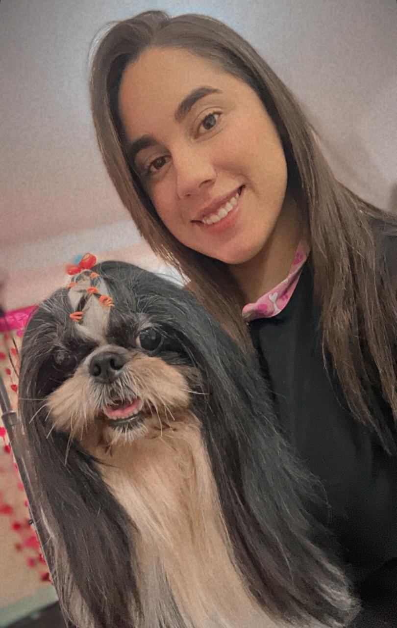 Geovana segurando um cachorro feliz após banho